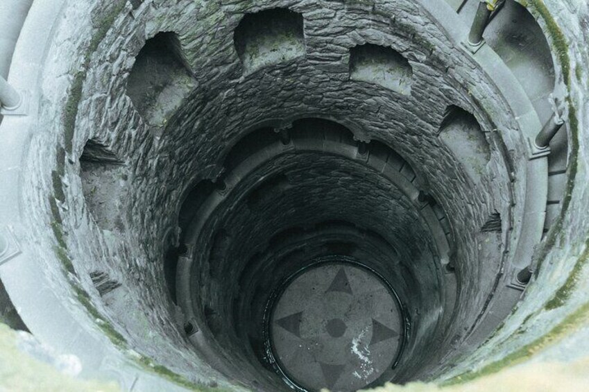 Un primo piano di una struttura circolare in pietra consumata dal tempo, con un'apertura centrale. 4