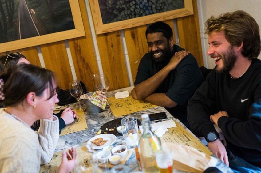 Eine Gruppe von Personen sitzt an einem Tisch mit Essen und Getränken. 3