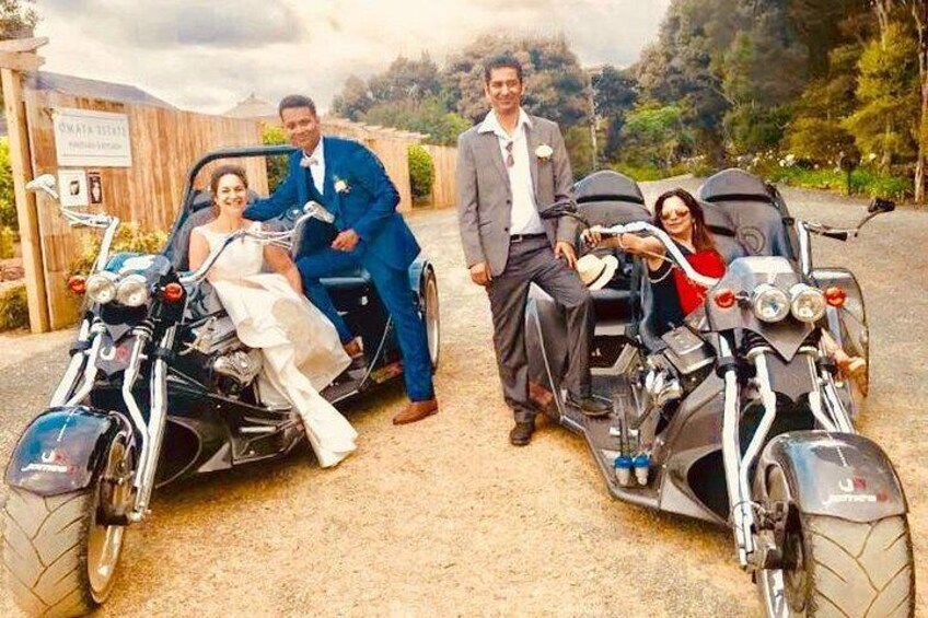 Escena de boda con una novia y un novio en una motocicleta, un hombre con traje y una mujer con un vestido rojo. 4