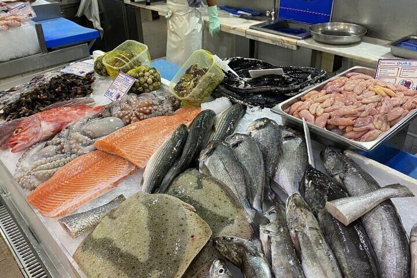 Variedad de mariscos frescos, incluyendo pescado, camarones y mejillones, exhibidos en un mercado. 5