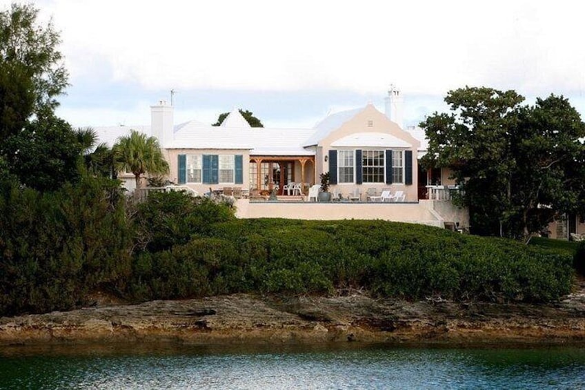 A coastal house with a large patio, a swimming pool, and a view of the ocean. 3