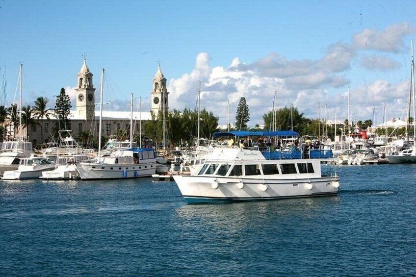 A marina with several boats docked, a prominent building with two towers, and a clear blue sky. 4