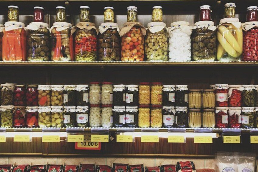 Shelves stocked with various jars of pickled vegetables and fruits. 2