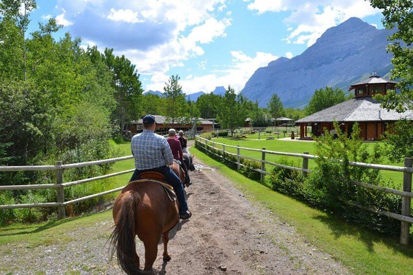 Un sentiero sterrato con recinzioni in legno, un cavallo e cavalieri. 2