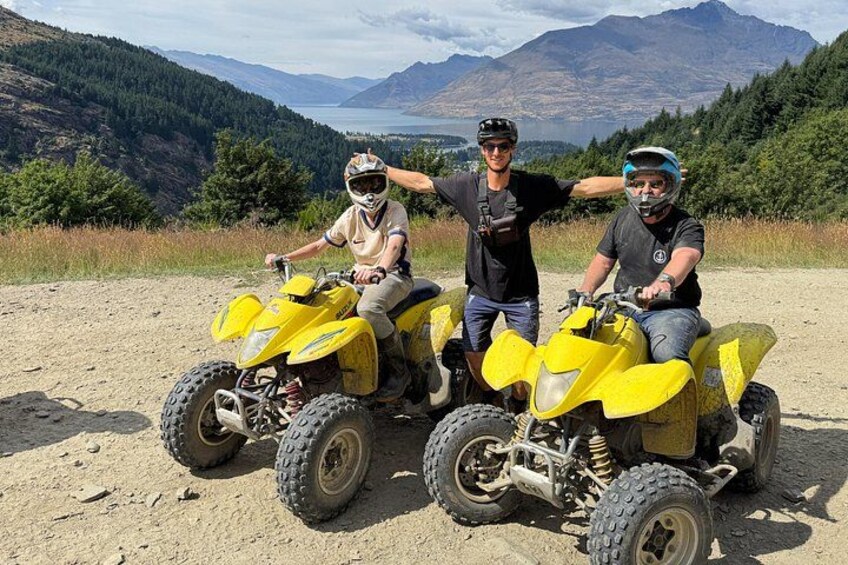 Dos personas en vehículos todo terreno amarillos (ATVs) en un camino de tierra con un paisaje montañoso al fondo. 4