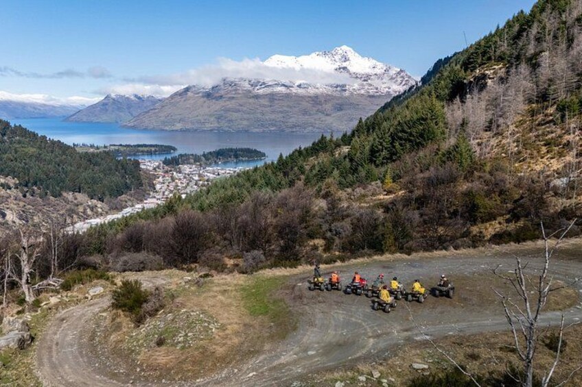 Paisaje montañoso con un lago, una carretera con vehículos y un pequeño asentamiento. 2