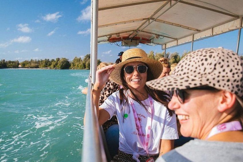 Un bote en un mar turquesa con gente usando sombreros y gafas de sol. 3