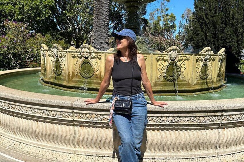 A person standing by an ornate fountain with intricate carvings. 2