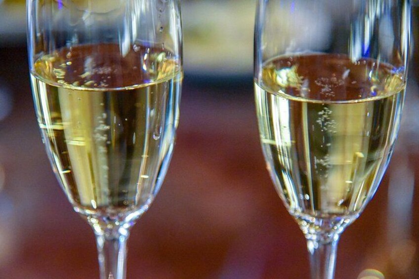 Två champagneglas fyllda med en klar vätska, troligen champagne, med kondens på glasets yta. 3