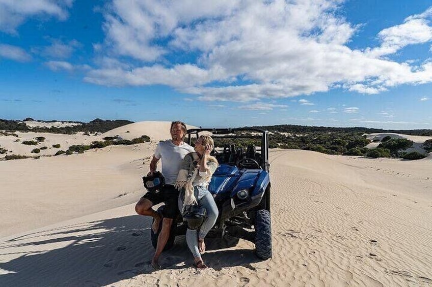 Paisaje desértico con dunas de arena y un buggy estacionado sobre la arena. 3