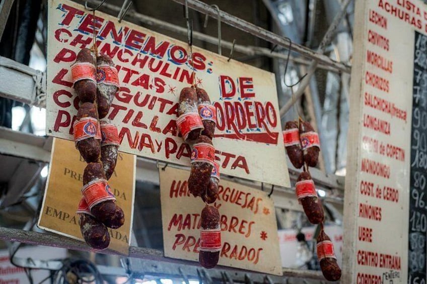 A food stall with signs advertising various meats and prices. 3