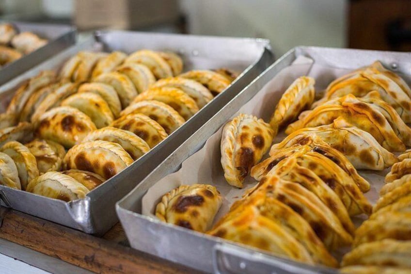 A tray of baked pastries with golden-brown crusts. 4
