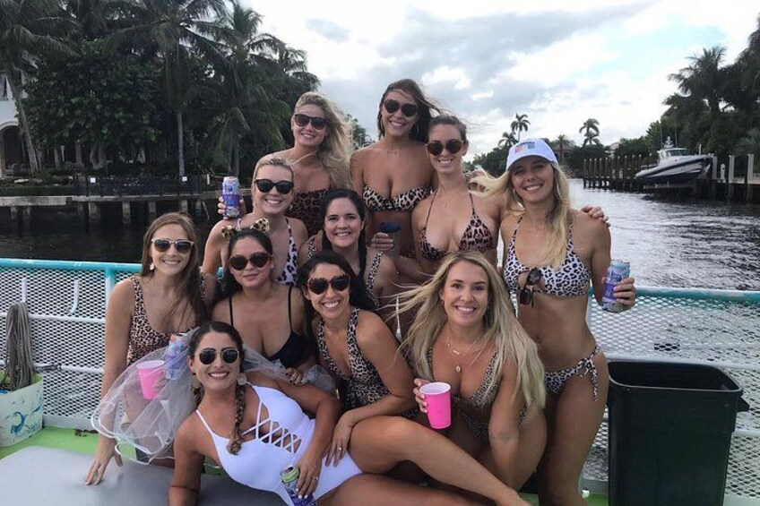 Un grupo de personas en un bote cerca de un cuerpo de agua con palmeras al fondo. 2