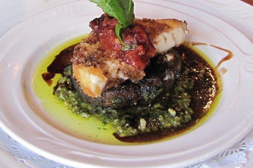 A plate of food with a fish fillet, a red sauce, and a green sauce. 4