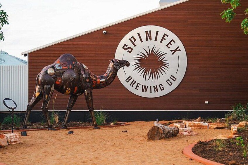 Una scultura a forma di cammello di fronte a un edificio con un cartello che riporta la scritta 'Spinifex Brewing Co.' 2