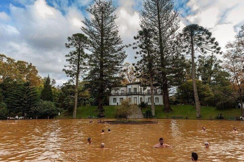 A swimming pool with people, surrounded by trees and a building. 3