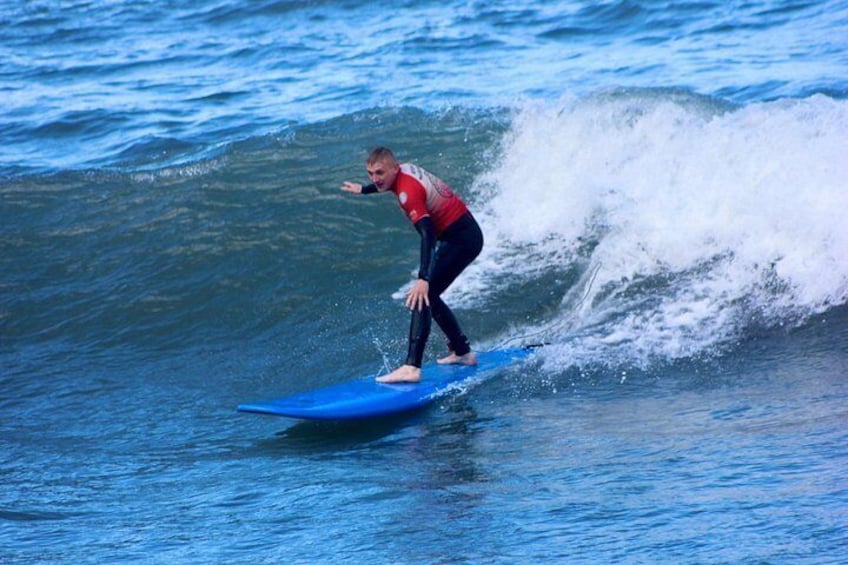 Una persona surfeando sobre una tabla azul en el océano. 1