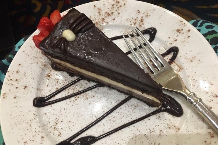 Una fetta di torta al cioccolato con fragole e una cucchiaiata di panna su un piatto. 3