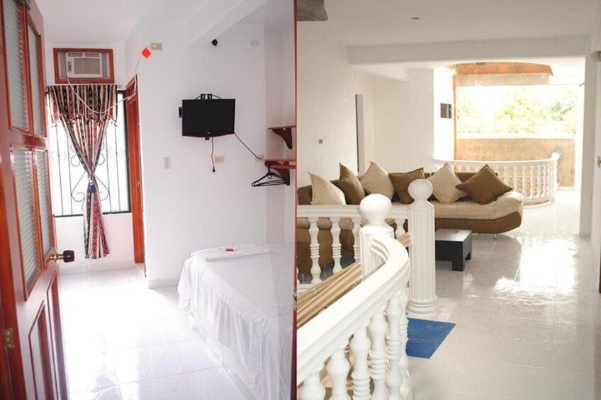 A room with a bed, a TV mounted on the wall, and a balcony with a railing. 5