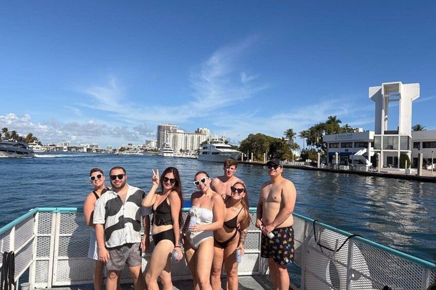 A group of people on a boat with a city skyline and water in the background. 5