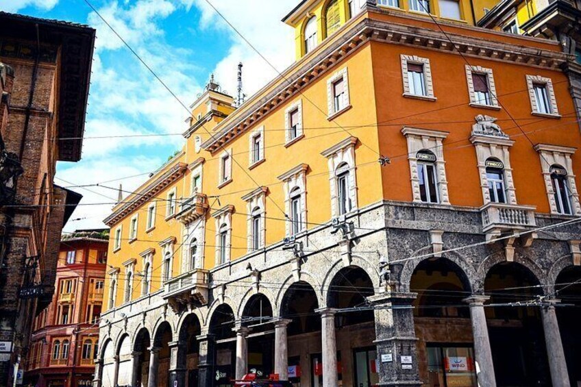 Un edificio amarillo con ventanas de arco y fachada de piedra. 4