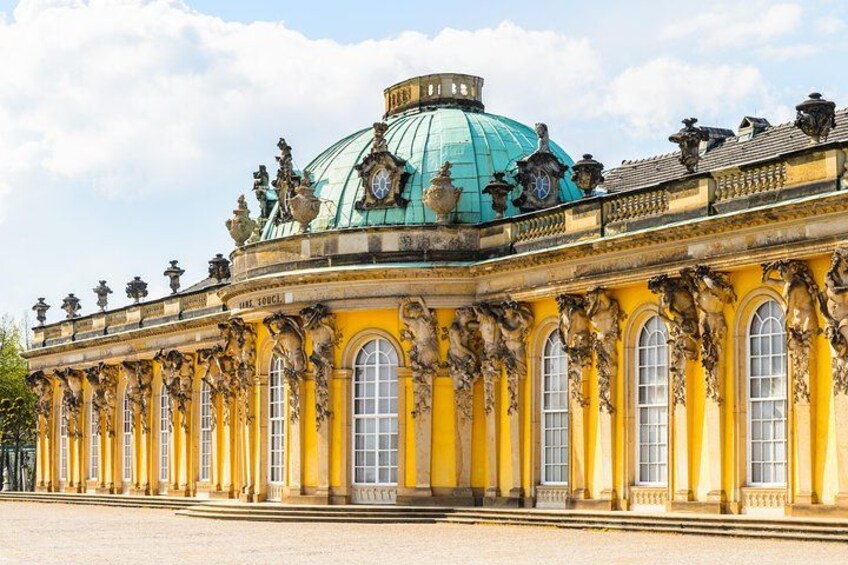 A grand yellow building with a large green dome and ornate decorations. 1