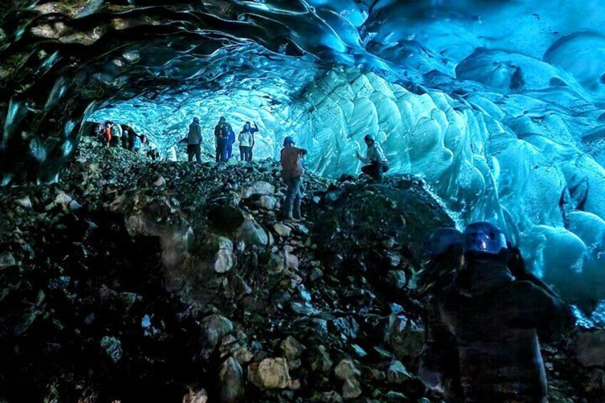 Un groupe de personnes se trouve à l’intérieur d’une grotte, où l’on peut observer des formations de glace. 5