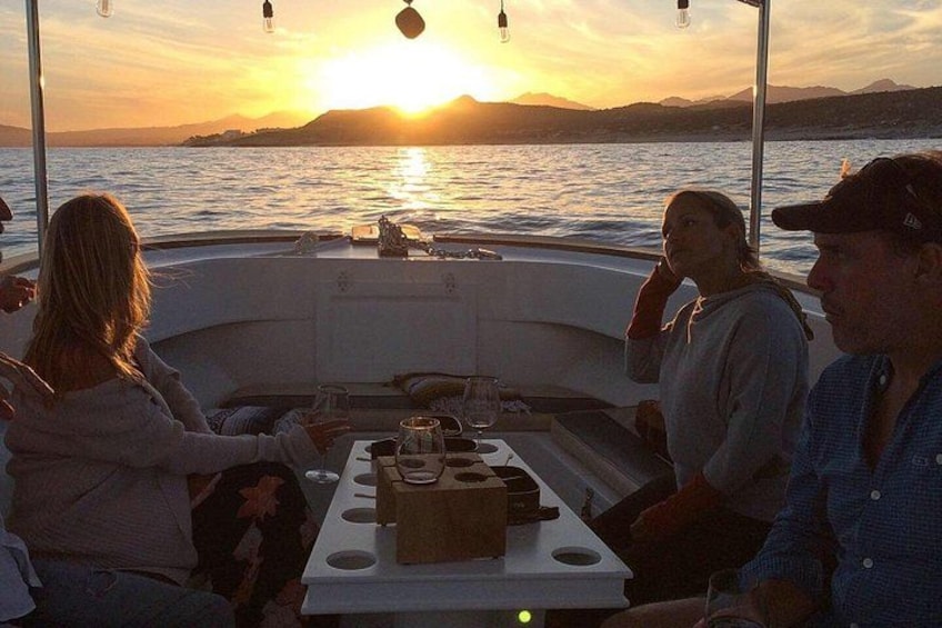 A boat with people dining at sunset. 4