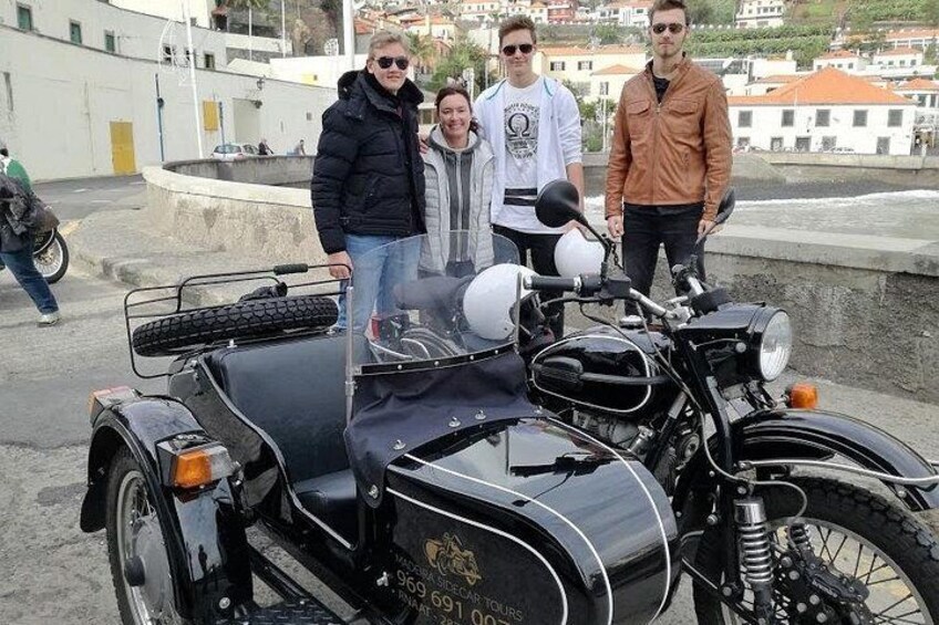 A vintage motorcycle with a sidecar parked on a paved area. 5