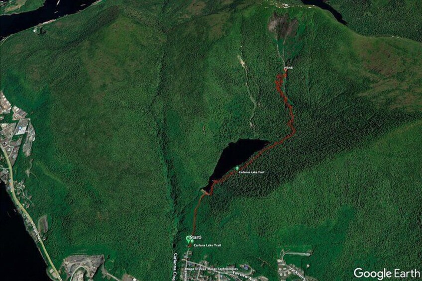 A satellite view of a forested area with a red trail marked as the 'Carlsberg Lake Trail.' 2