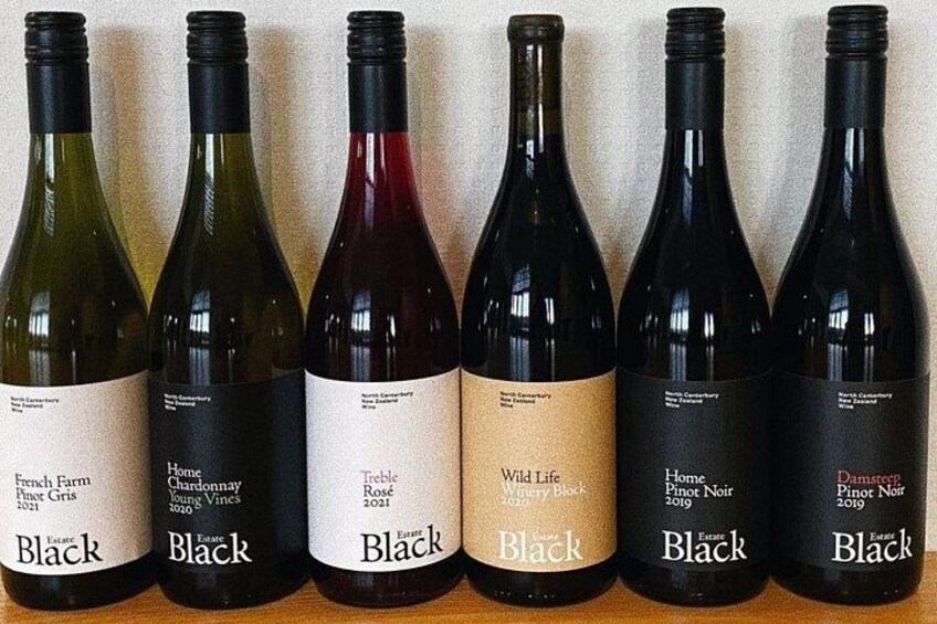 Seis botellas de vino con etiquetas, dispuestas en fila. 4