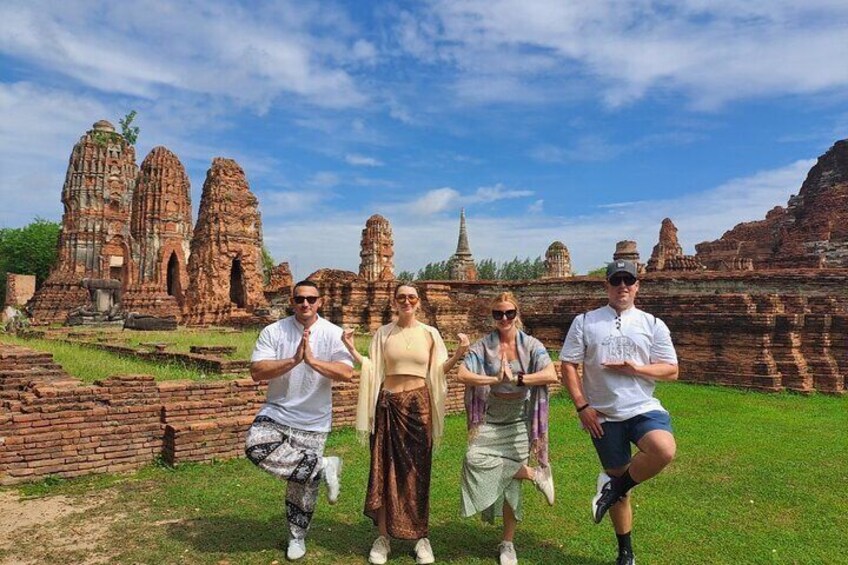 A group of people in traditional attire posing in front of ancient ruins. 4