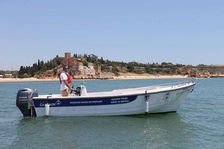 Un barco llamado 'Captain' sobre aguas tranquilas, con un paisaje costero al fondo. 2