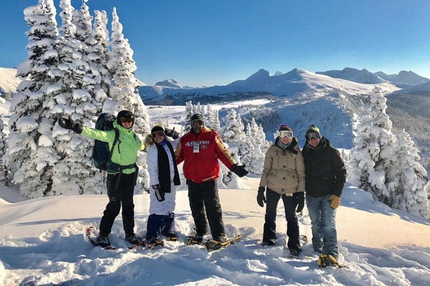 A group of people on a snowy mountain with snow-covered trees and a clear sky. 2