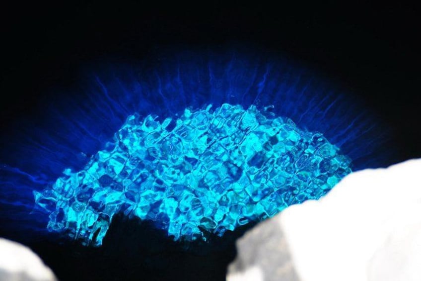 A blue crystalline structure with a dark background. 1