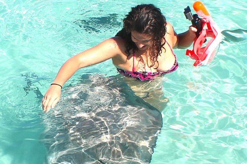 A person in a pool with a rock and a floatation device. 3