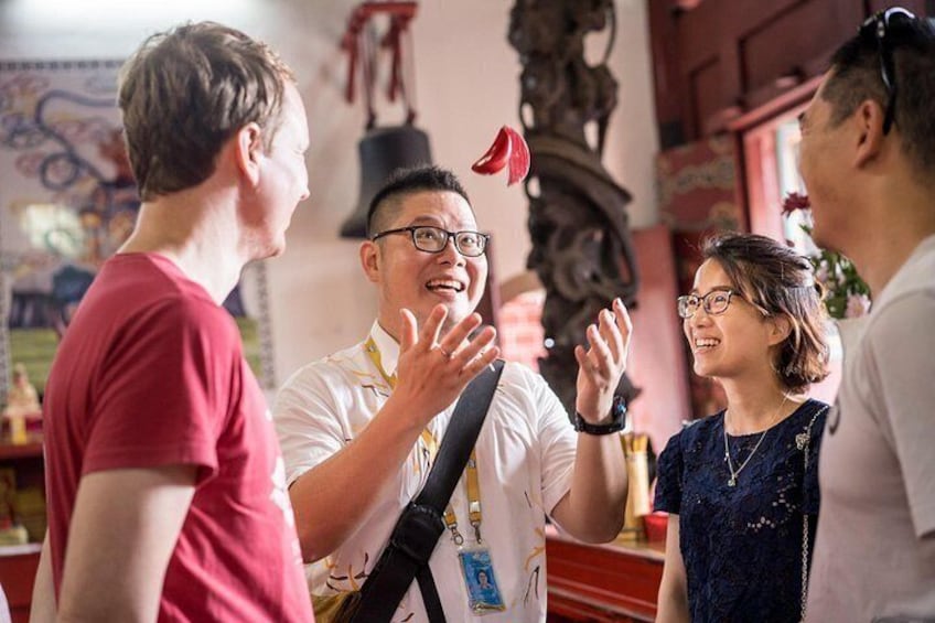 A group of people in a room with a red and white color scheme, a decorative ceiling, and a person wearing a white shirt with a name tag. 3