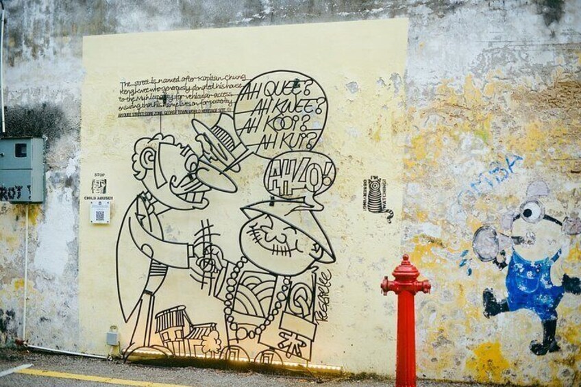 Un mur orné d’une fresque représentant un homme et une femme, un hydrant rouge et un personnage de dessin animé. 2