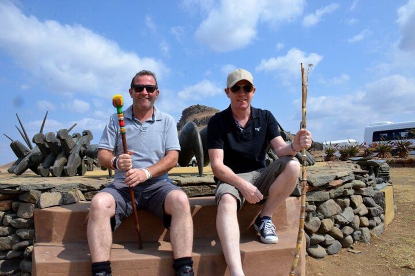 Two people sitting on steps outdoors with tools in hand. 2