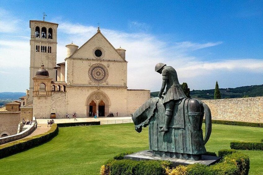 A church with a bell tower and a statue of a knight on horseback. 1