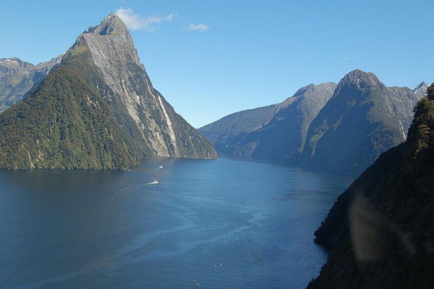 En fjord med et markant bjergtop, stille vand og en klar himmel. 3