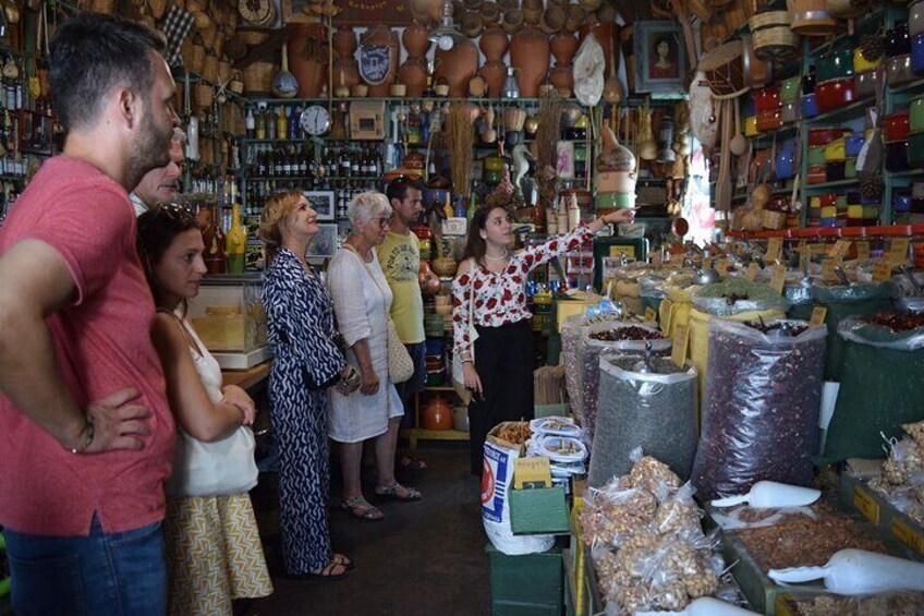 Un mercado con gente mirando y una mujer señalando productos. 3