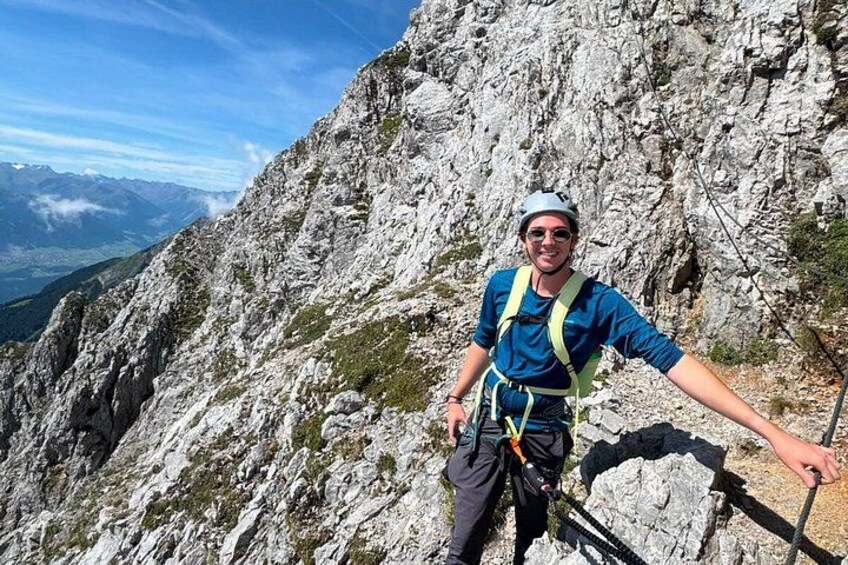 A person on a mountain ridge with rocky terrain and distant mountains. 2