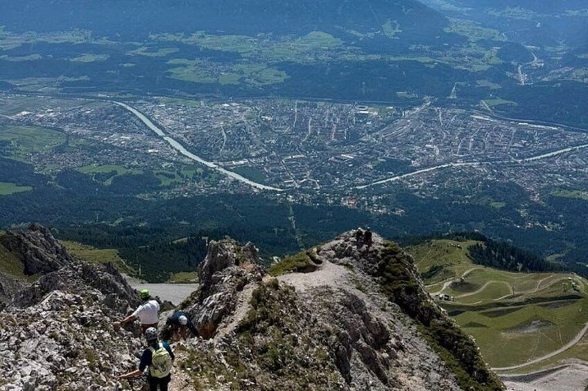 A mountainous landscape with a city in the distance, rocky terrain, and a clear sky. 5