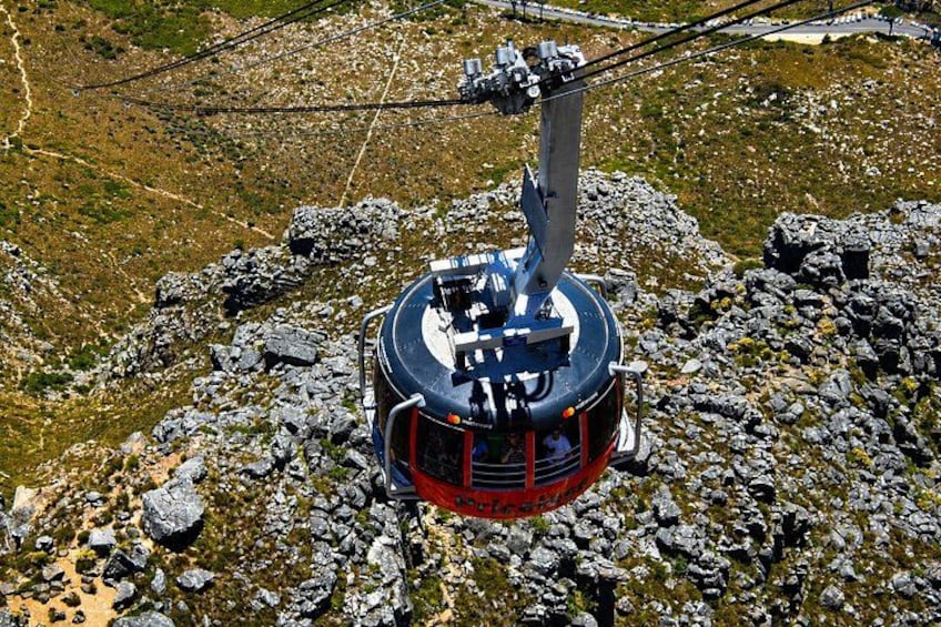 A cable car system with a red and black cabin suspended by cables. 4