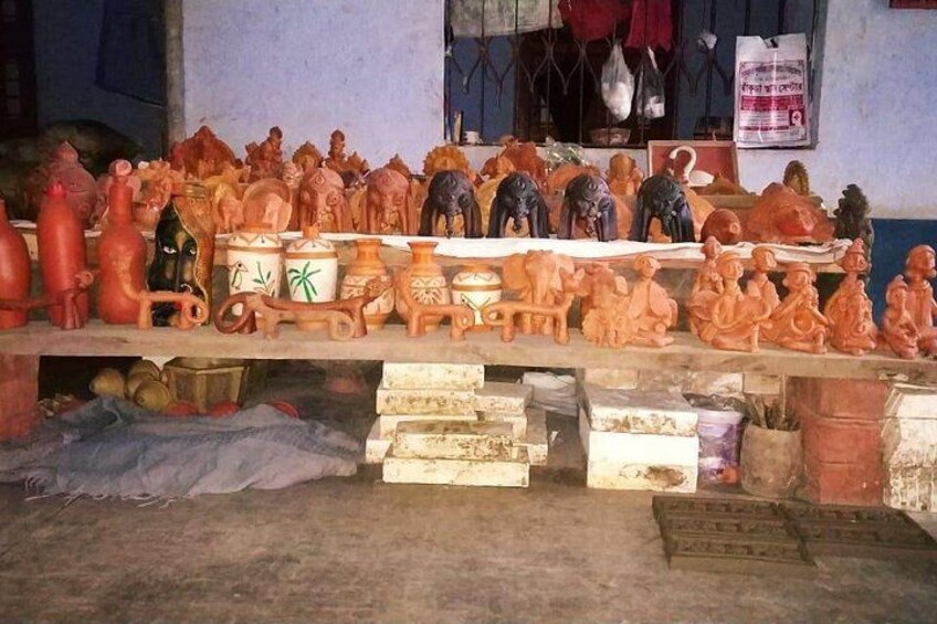 A variety of pottery and sculptures displayed on shelves. 1