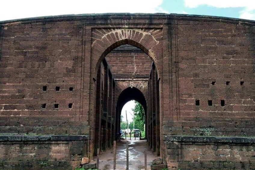 A brick archway with a pathway leading through it. 2