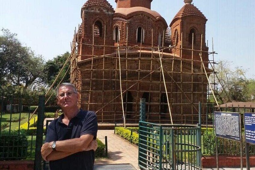 A man standing in front of a building under construction with scaffolding. 4