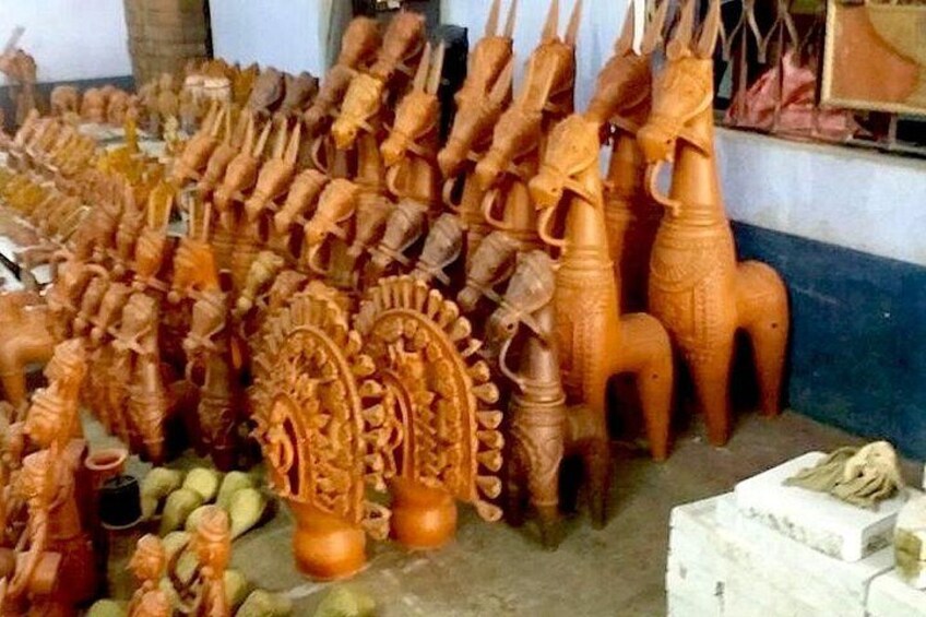 A collection of intricately carved wooden sculptures, including figures and animals, displayed on a shelf. 5