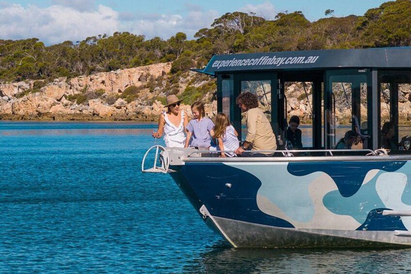 Ein Boot mit Personen an Bord, Wasser und eine felsige Küste. 2